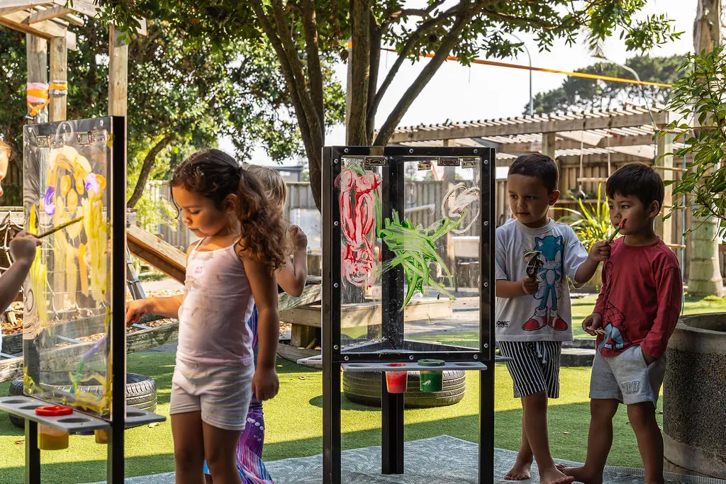 Children painting together at a Play'n'Learn aluminium easel outdoors