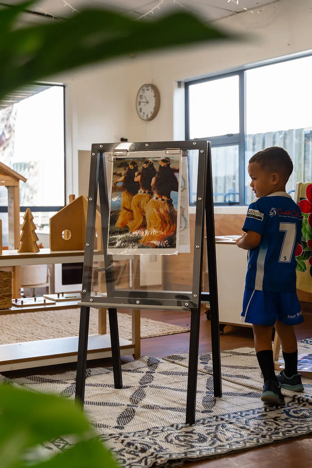Children painting at an aluminium easel in an outdoor early-learning playground
